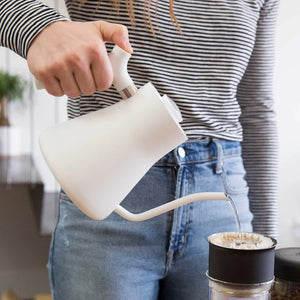 Käsi valab vett valgest kitsas suuga veekeetjast kohvifiltri kohale, osa EspressoGearist, kõik kohvi kohta.