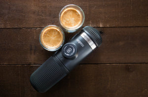 Kaasaskantav espressomasin kahe tassi espressoga puidust pinnal, kaasaskantavate kohvimasinate ja barista varustuse hulgast